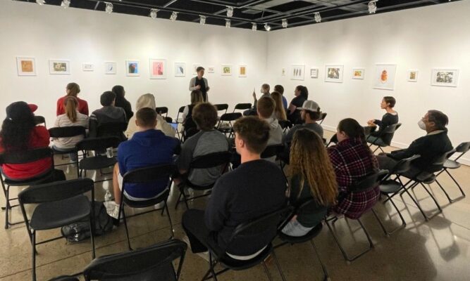 Newman University students attend a showcase in the Steckline Gallery.