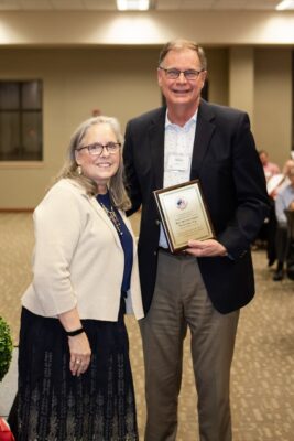 Alumnus Mike Ludlow, on behalf of West Wichita Family Physicians, collects a plaque for the De Mattias Society.