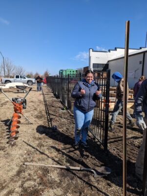 Isabel Porres smiles for a photo while helping put the fence up. 