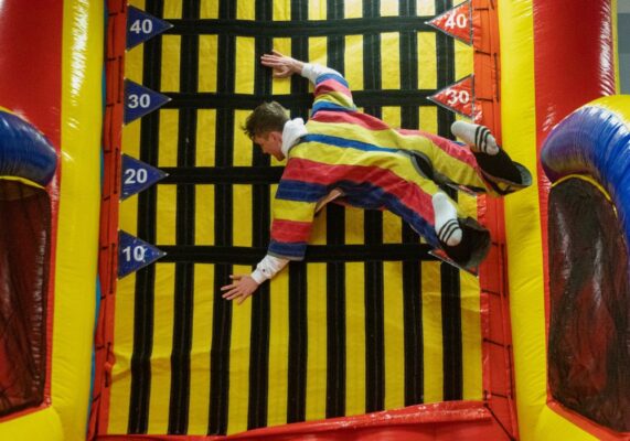 A student launches onto the velcro wall.