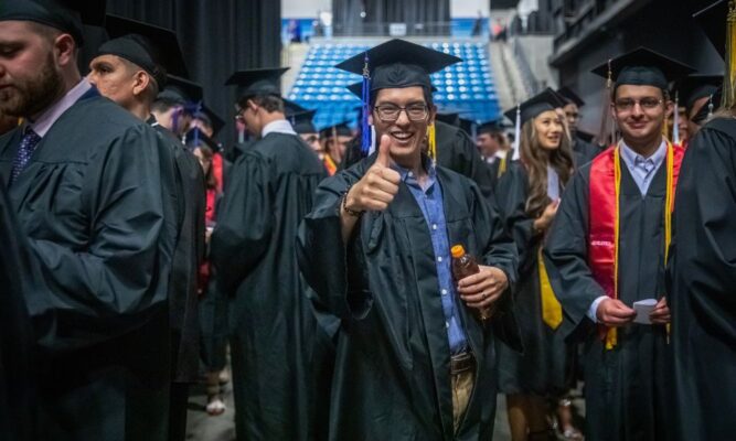 Nguyen gives a thumbs up during Newman commencement day at Hartman Arena.