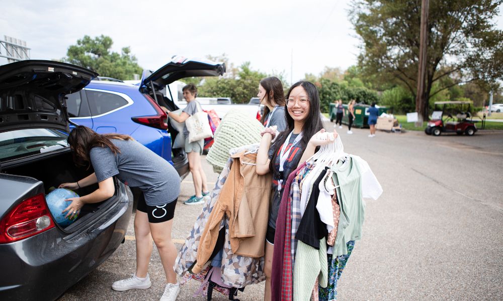 A Newman University student carries her clothes into the residence halls.