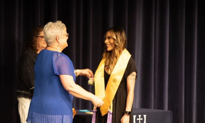 A Newman graduate receives her nursing pin from Director of Nursing Teresa Vetter.