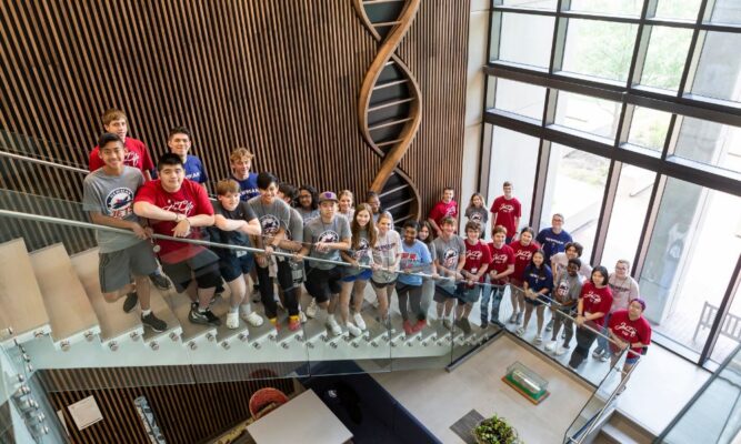 Campers of the Investigative Summer STEM Program gather for a group photo on the staircase of the Bishop Gerber Science Center at Newman University.