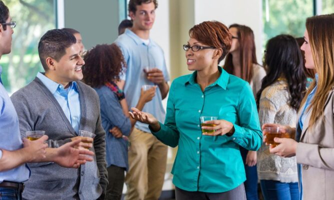 Guests mingle with drinks at an alumni mixer.