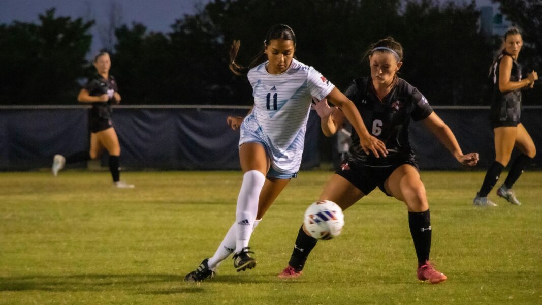 A player from the Newman University women's soccer team takes possession of the ball during an evening game.