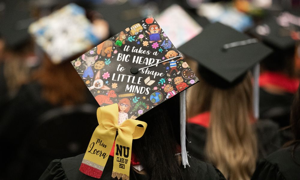 Education graduate's cap reads "It takes a big heart to shape little minds."