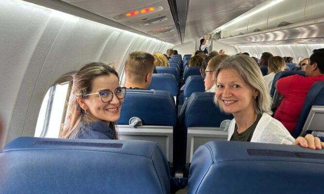 Professors Cinthia López and Sonja Bontrager smile on the plane to Guatemala.