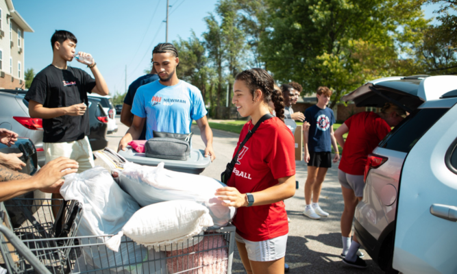 Amaya Perez (center) helps load a shopping cart with items for a student's room in the residence hall.