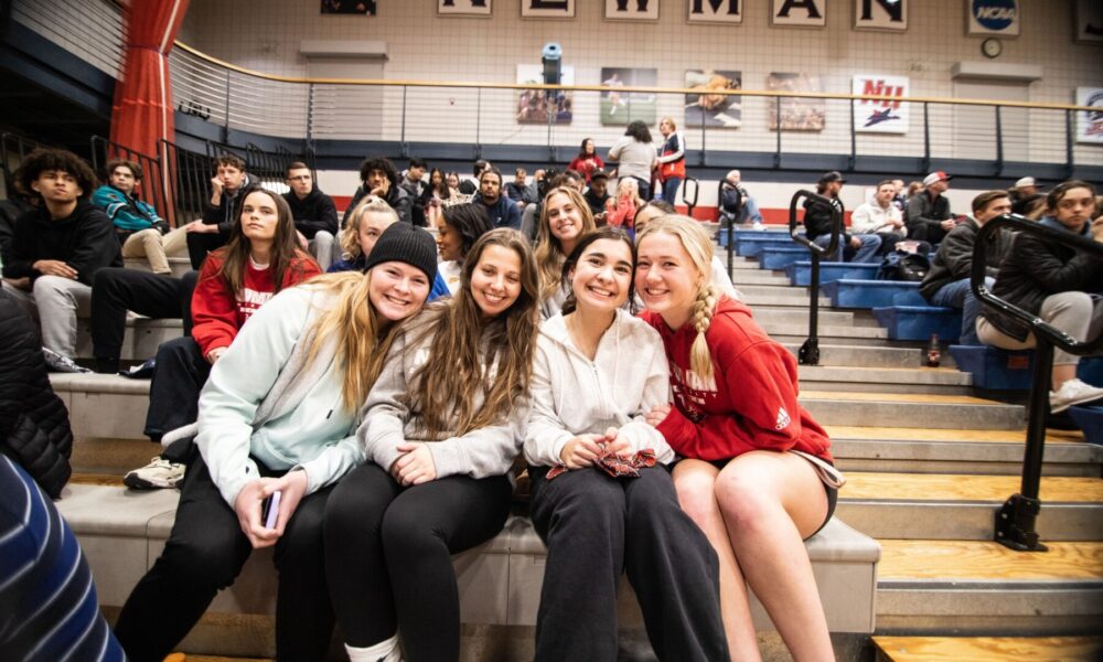 Students gather in the stands during an exciting men's basketball game.