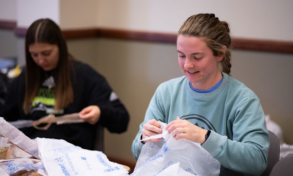 Students smile as they donate their time during service day at Newman.