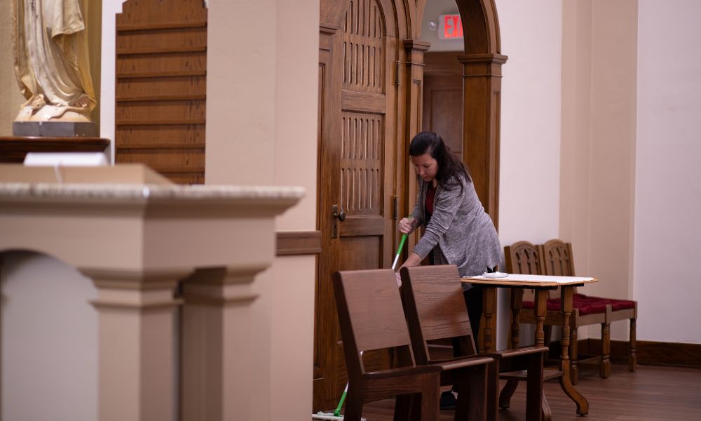 Kara Schwinn, assistant director of financial aid, sweeps in St. John's Chapel during Service Day.