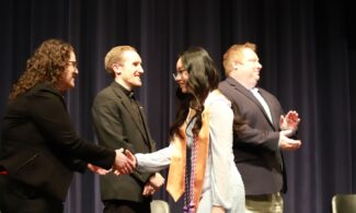 Angela Tran walks the stage as she receives her ceremonial nursing pin, Dec. 2023.