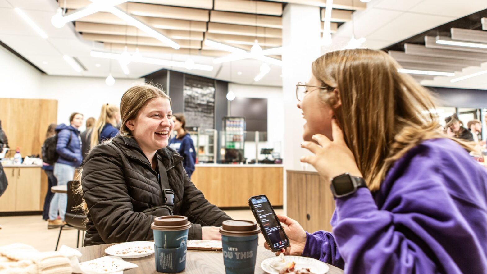 Two students interact over coffee at Sacred Grounds Coffee & Café in the Student Success Center.