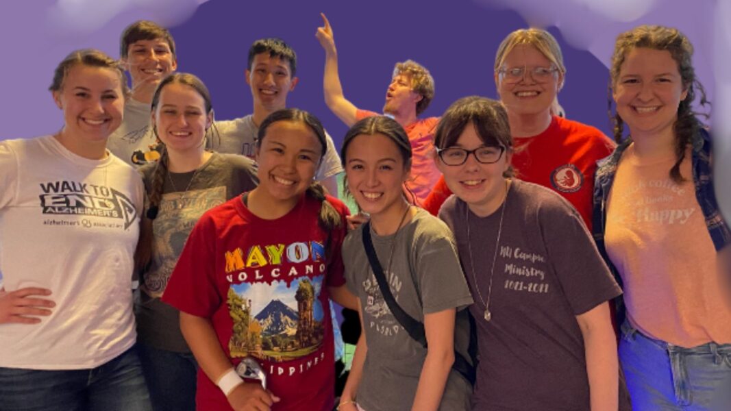 10 Campus Ministry students smile with a purple background.