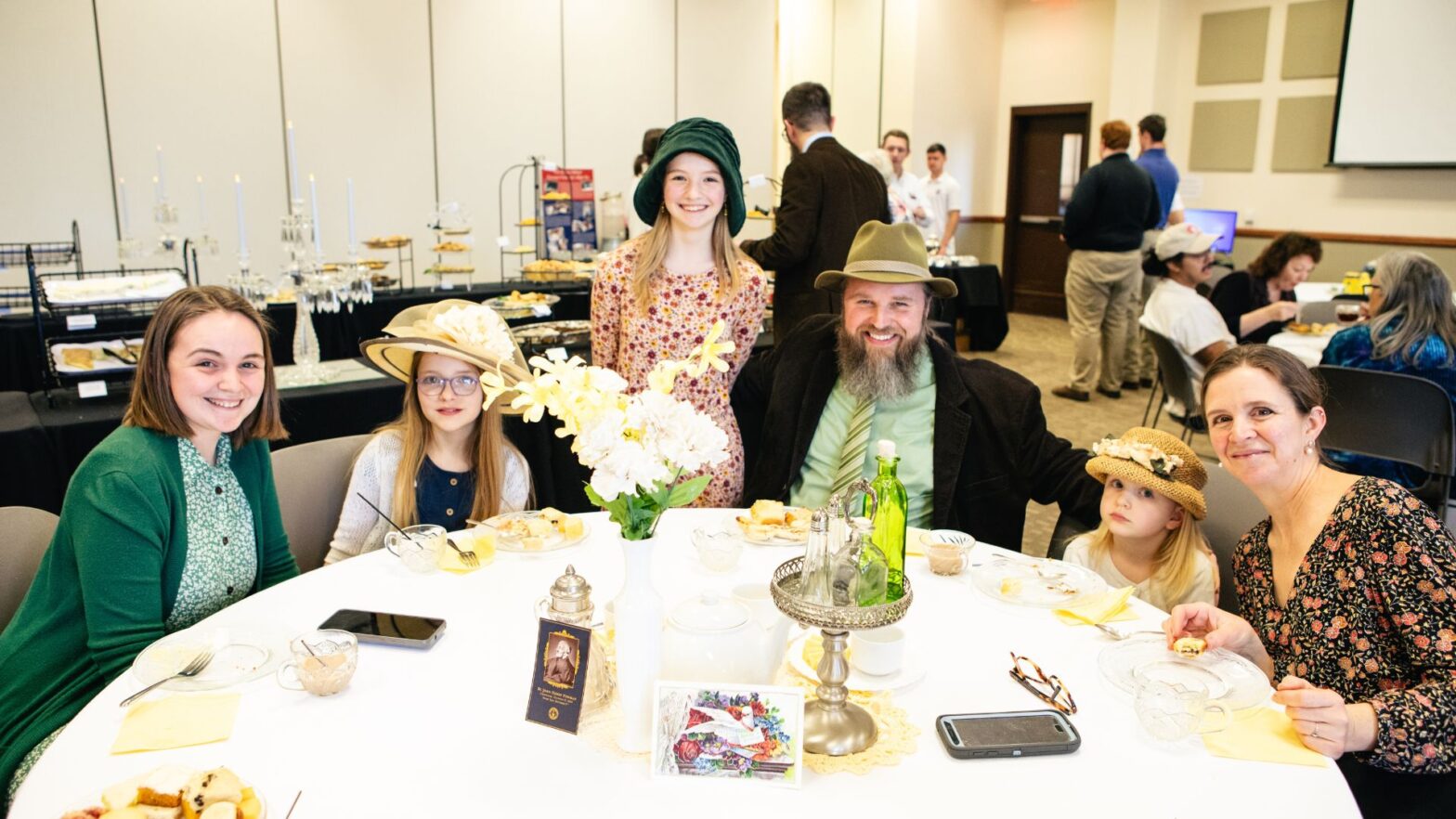 The Umbarger family sits at a table during the St. John Henry Newman High Tea event in the Dugan-Gorges Conference Center.