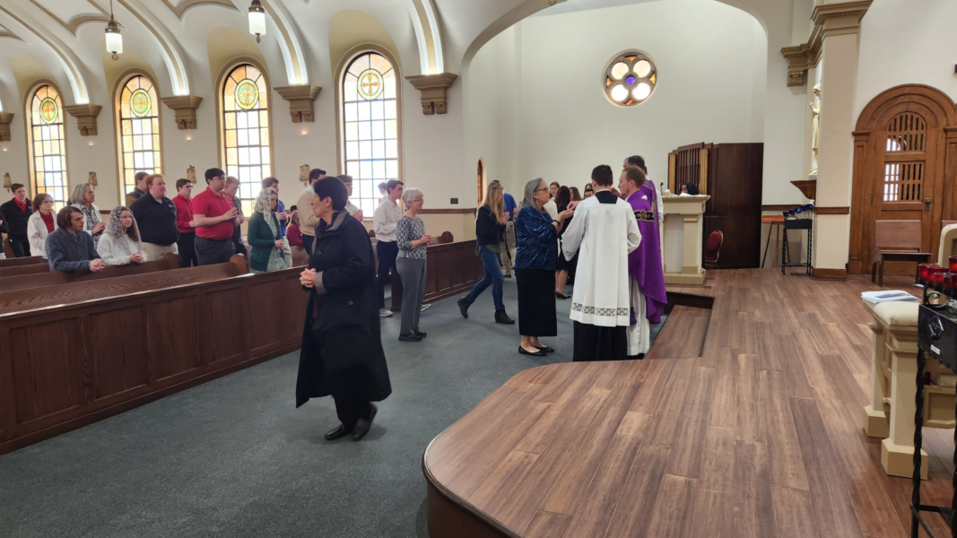 Catholic community members receive communion during the St. Newman Mass in St. John's Chapel.