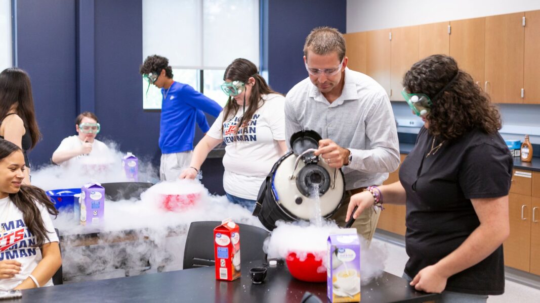 Professor Huschka helps students conduct a liquid nitrogen experiment in a Newman University lab.