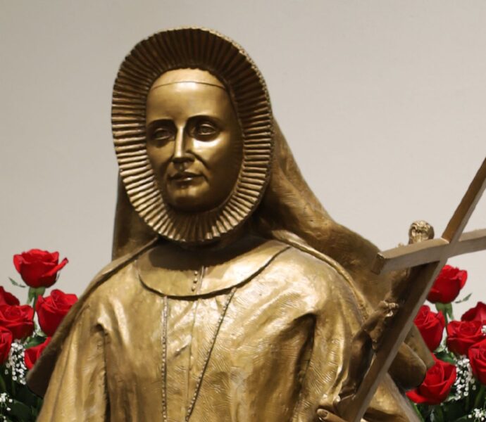 St. Maria De Mattias sculpture with red roses in the background.