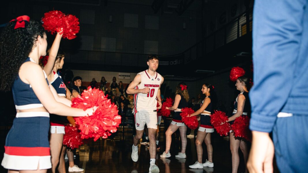 Sam Somerhalder enters the homecoming night game, surrounded by Newman's Cheer and Dance team.