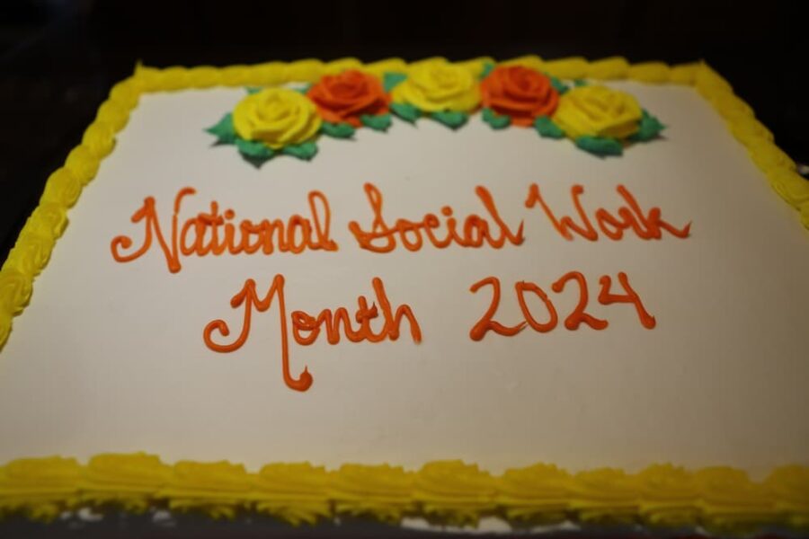 A white sheet cake reads "National Social Work month 2024"