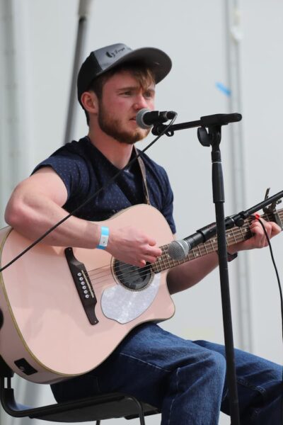 Student and singer-songwriter Hunter Lough performs with his guitar during the event.