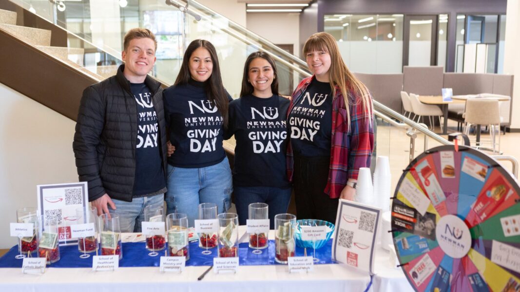 (From left to right) Newman staff members Jack Schafer, Katherine Reynoso, Daniela Correa and Abbi Timmermeyer at the student booth on Giving Day.