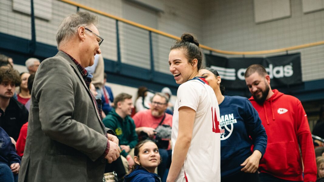 Professor Mark Mannette congratulates Perez following the homecoming game at Newman University.