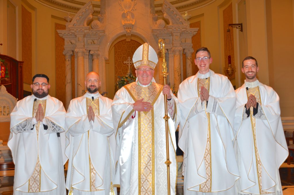 Bishop Carl A. Kemme ordained four men to the priesthood Saturday, May 25. From left are Jesus Bañuelos, Miles Swigart, Caleb Kuestersteffen and Matthew Cooke. (Advance photo)