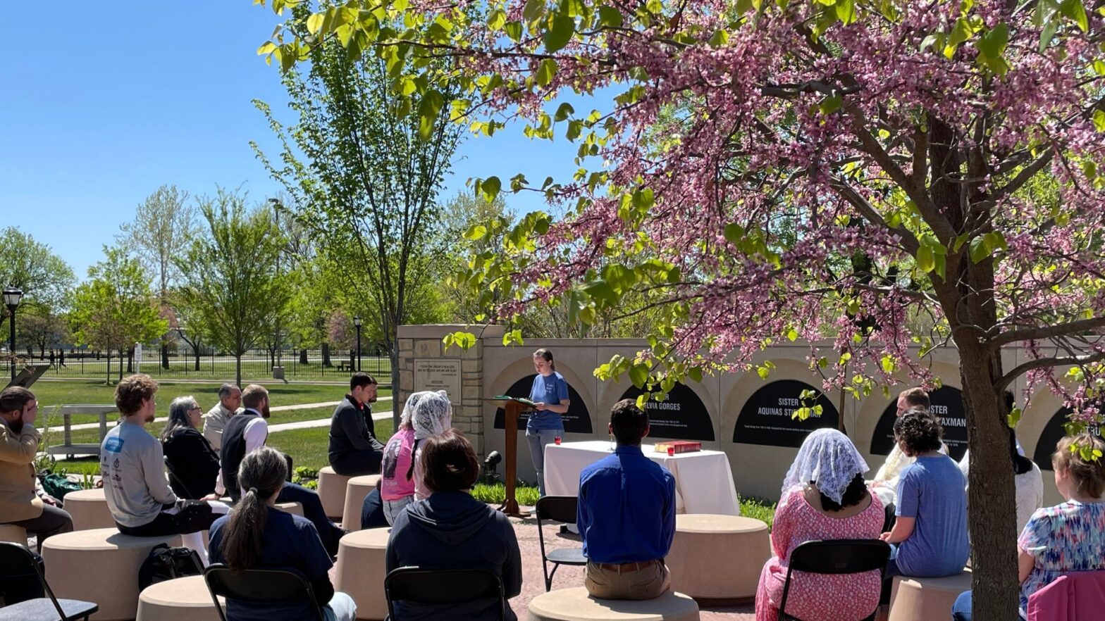 Students, staff and faculty attend an outdoor "Green Mass" on campus during Earth Week 2023.