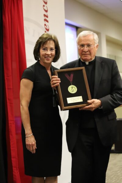 (From left to right) Board of Trustees Chair Jenifer Stone, APRN, ’87, ’93 and Father Tom Welk