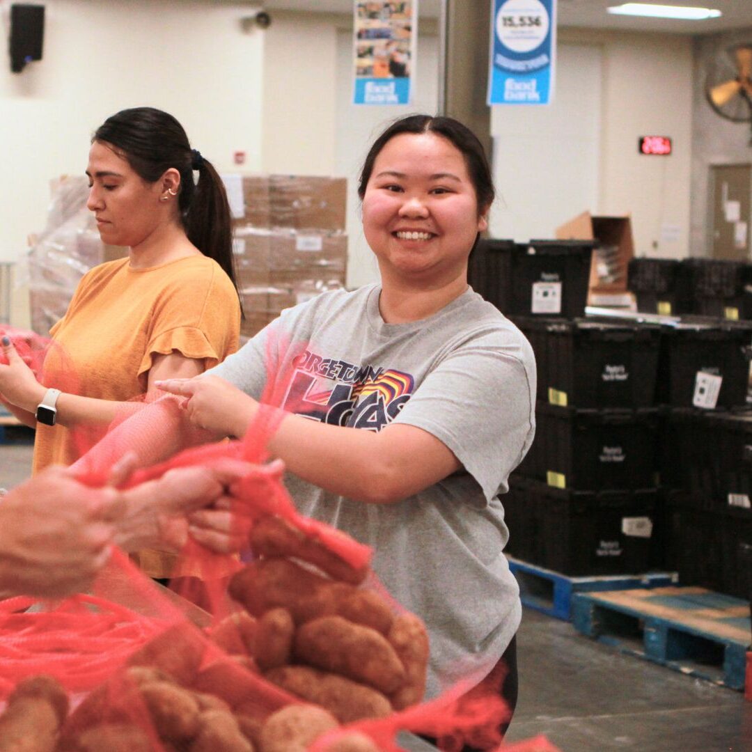 Ashley Dinh assembles five-pound bags of potatoes.