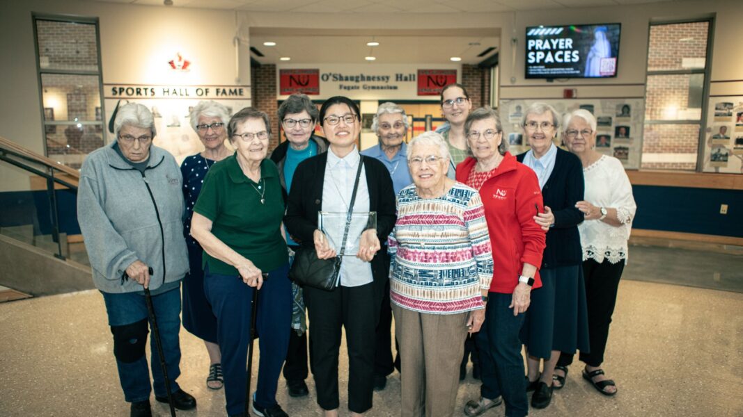 Kang (front, center) stands with her fellow ASC sisters following the Academic Awards Convocation in April at Newman.