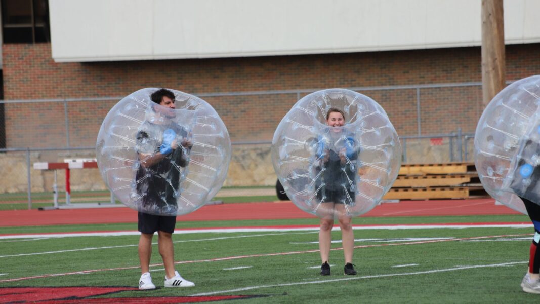 (From left to right) Newman soccer player Juan Carlos Cordova and Helfrich compete against Friends University students during a game of bubble soccer.