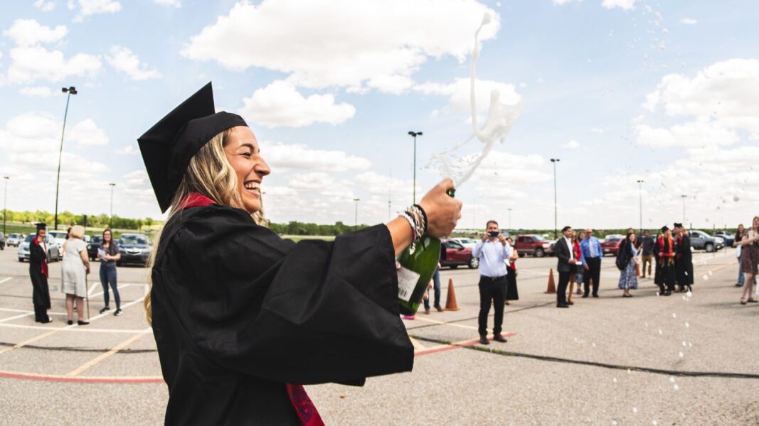 Graduate Martina Lolli celebrates with champagne following the commencement ceremony.