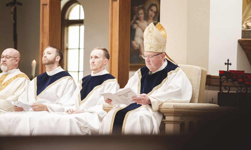 Bishop Kemme sits with fellow priests during Baccalaureate Mass