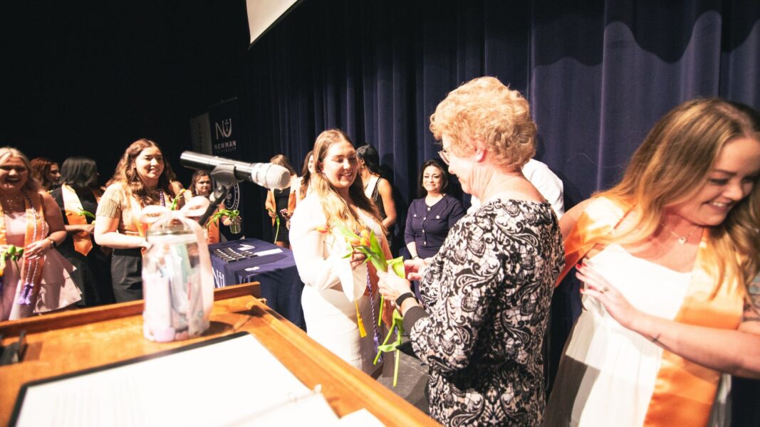 Students hand off flowers to Strickert as she enters retirement from Newman University.