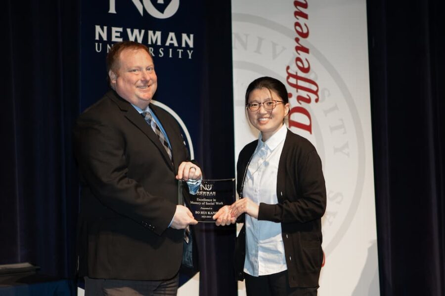 Kang accepts her Excellence in Mastery of Social Work award from Newman Vice President of Academic Affairs Alden Stout