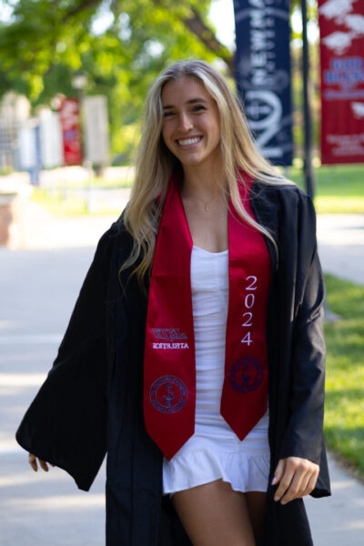 Weaver proudly wears her graduation gown and athletics stole on the Newman University campus. (Photo credit: Volleyball teammate Camryn Kindred)
