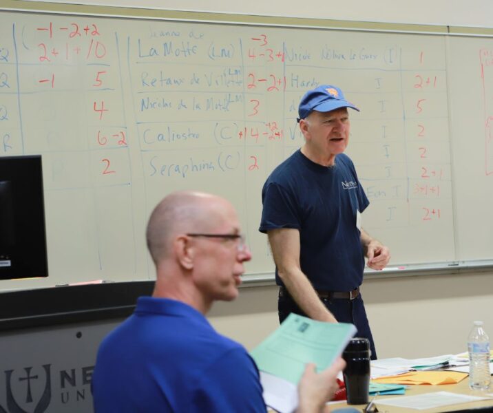 (In the foreground) Kelly McFall, Newman University professor of history and director of the Honors Program, talks with attendees of the Reacting to the Past Game Development Conference.