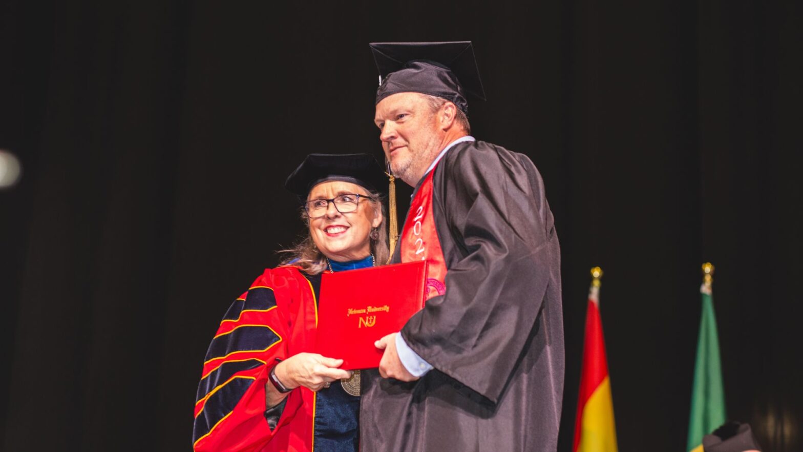 Coach Billy Murphy received his college diploma from President Kathleen Jagger during Newman University commencement day.