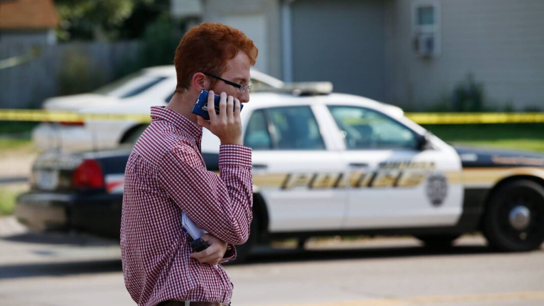 Riedl began his career as a crime reporter for the Wichita Eagle. He can be seen on the phone with a Wichita Police vehicle in the background.