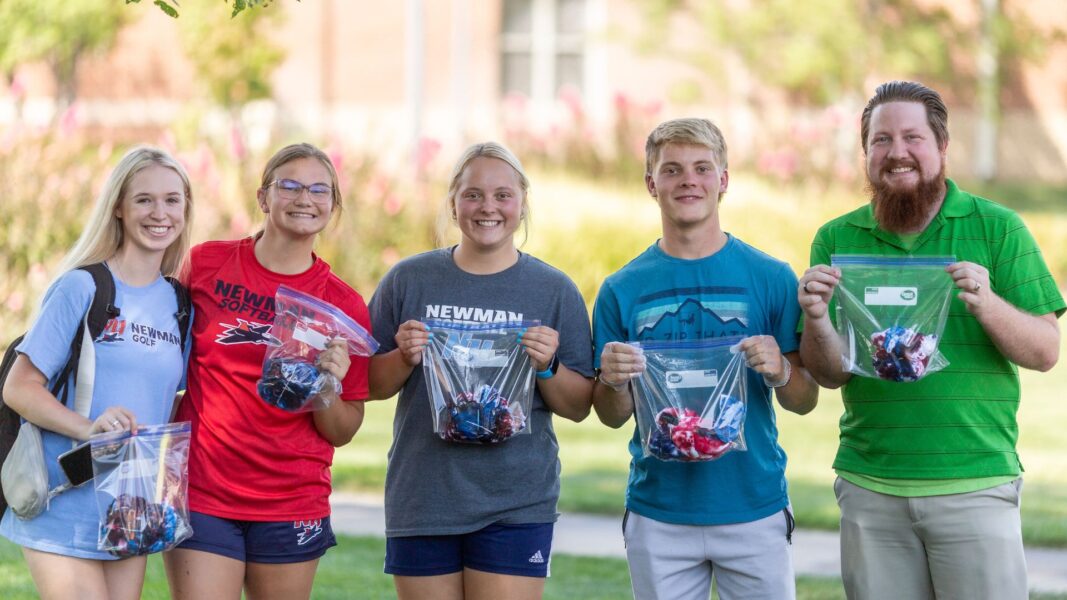 Students hold up their tie-dyed T-shirts during back to school week.