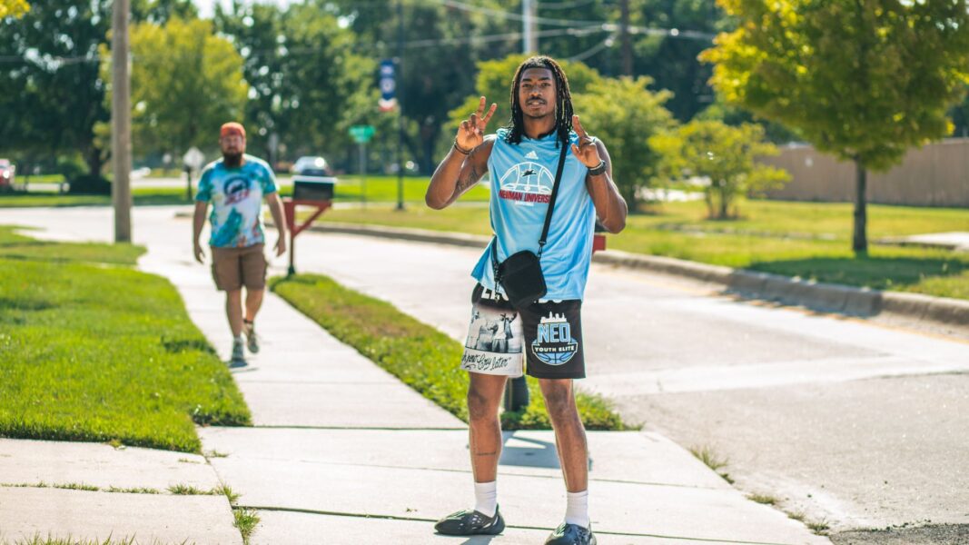 Jaden Gales, holding his hands in peace signs, heads from the residence halls to the gym on move-in day.