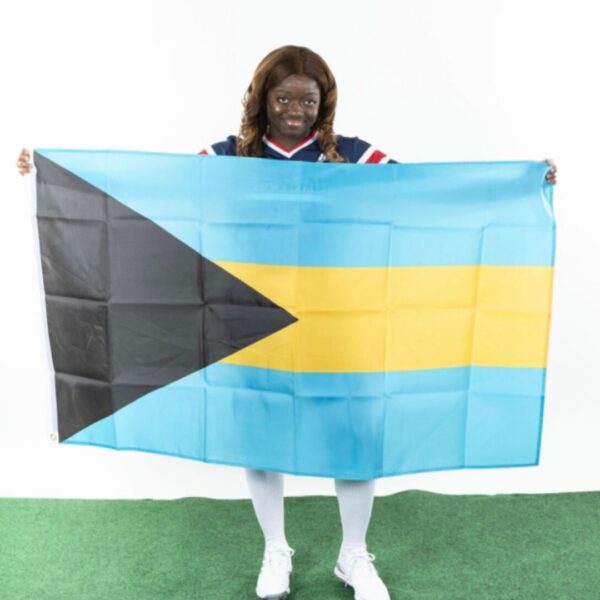 Travia Smith holds up a Bahamian national flag during media day at Newman University.