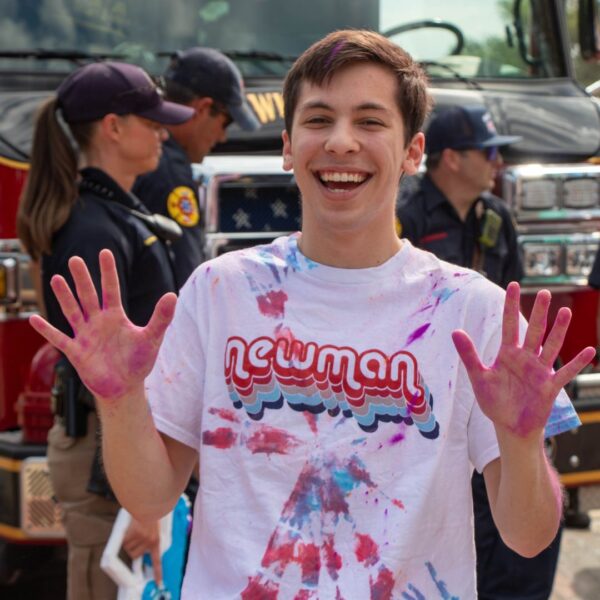 Mitchell holds up his colorful hands during the Newman Color Run in August 2024.