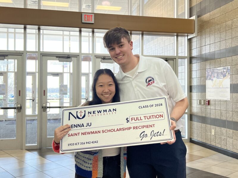 2024 graduate Joshua Dessenberger presented Ju with the St. Newman full-tuition scholarship check.