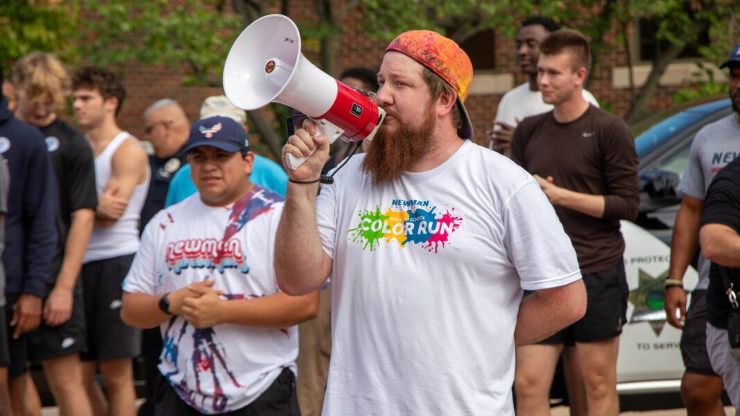 Schoenecker-Prilliman, director of student activities, holds a megaphone to get the attention of participants in the Color Run.