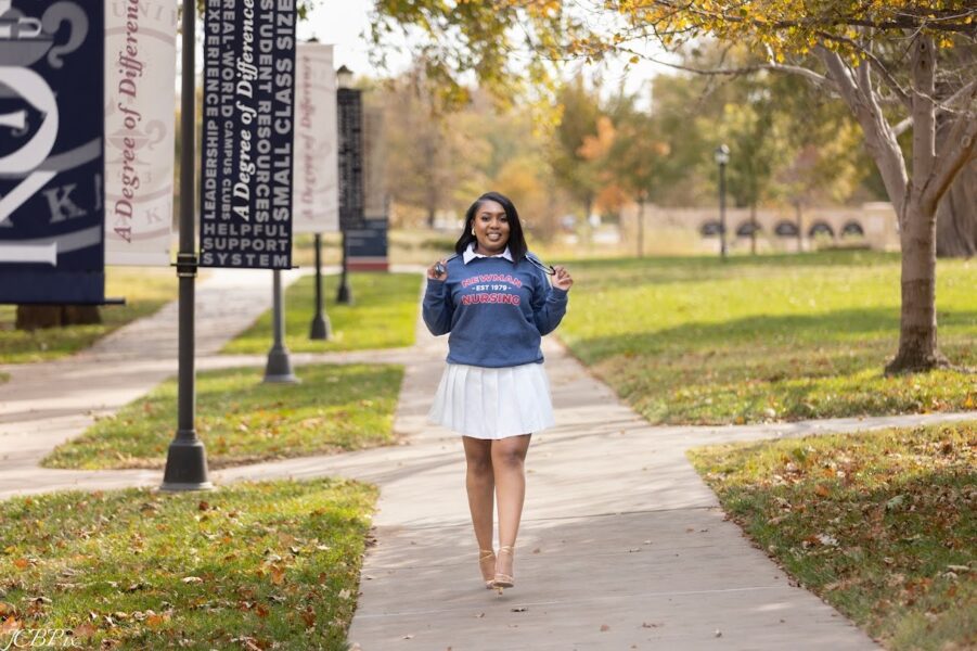 Kassita walks on a sidewalk on the Newman University campus. Photo courtesy of JCBPix Photography.