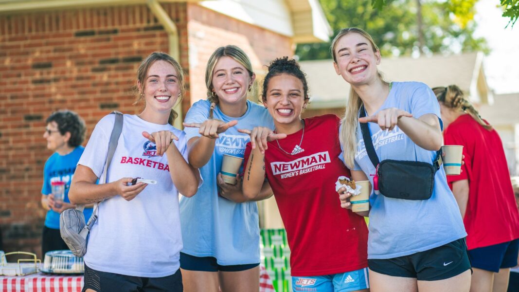 Lioukina (right) and fellow members of the women's basketball team help first-year students during move-in day at Newman.